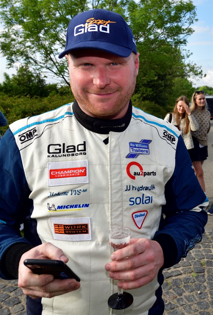 Champagne for at fejre sejren, telefon for at tjekke konkurrenternes tider. Kenneth Madsen er på toppen af dansk rally.
(Foto: Michael Eisenberg)